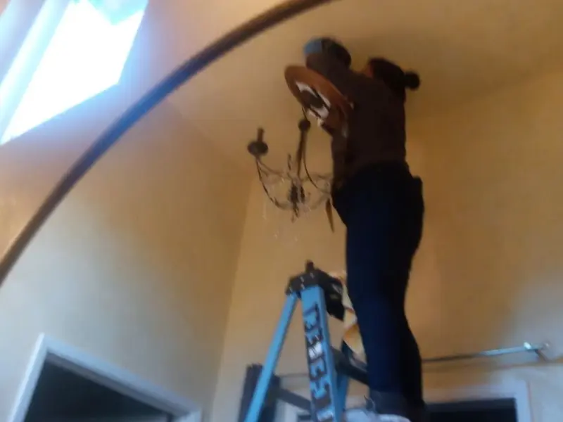 Electrician installing a chandelier in a Hillsborough residence